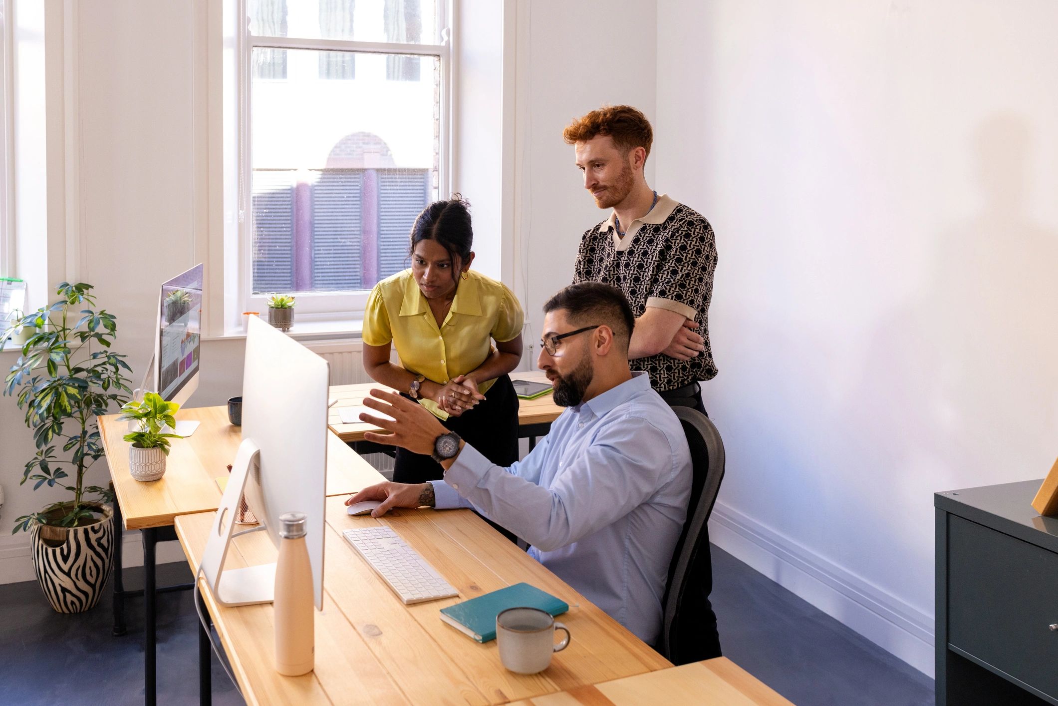 Small team collaborating around a desk in a shared office